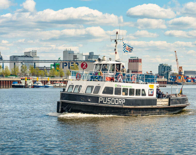 Auf dem Fluss Weser fährt das Fahrgastschiff Pusdorp. Im Hintergrund ist der Gröpelinger anleger Pier 2 / Waterfront zu sehen.