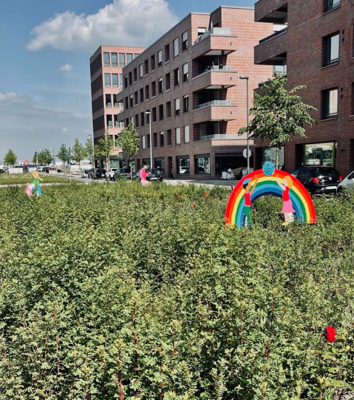 Der BBoulevard wird immer bunter. Regenbogen, Rollerfahrerin und Jogger sollen die Autofahrer:innen langsamer fahren lassen. 