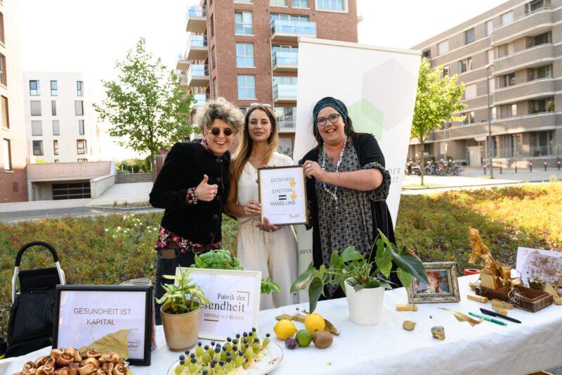 Drei gut gelaunte, lachende Frauen von Fabrik der Gesundheit an einem Picknick Tisch. 