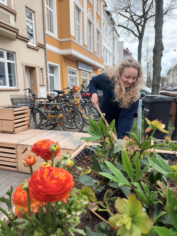 Janine von der Quartiersmeisterei gärtnert im Parklet in der Vegesacker Str.