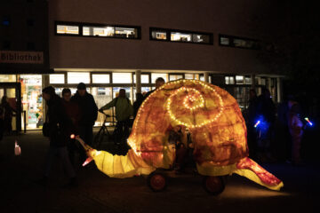 Ein Bollerwagen wurde zu einer Riesenschnecke umdekoriert, von Innen beleuchtet und dient als Laternentaxi für kleine Kinder beim Festival Feuerspuren.
