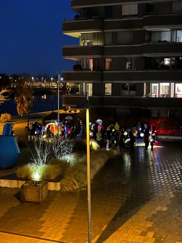 Der Laternenumzug von einem Balkon fotografiert. Die Gruppe biegt in die Ehrenfelsstraße ein. 