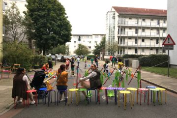 Die Spielstrasse wurde am Kunskiosk in der Dirschauer Straße eröffnet. Zu sehen sind Nachbarinnen und Kinder die Spielen.